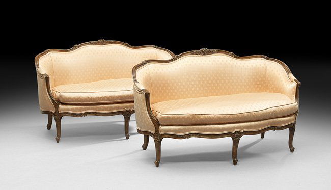 Pair of Louis XV-Style Mahogany Settees: Pair of Louis XV-Style Mahogany Settees, each with a padded back surmounted by a molded floral-carved crest, joined by downswept padded arms to the cushioned seat, raised on molded cabriole legs endin