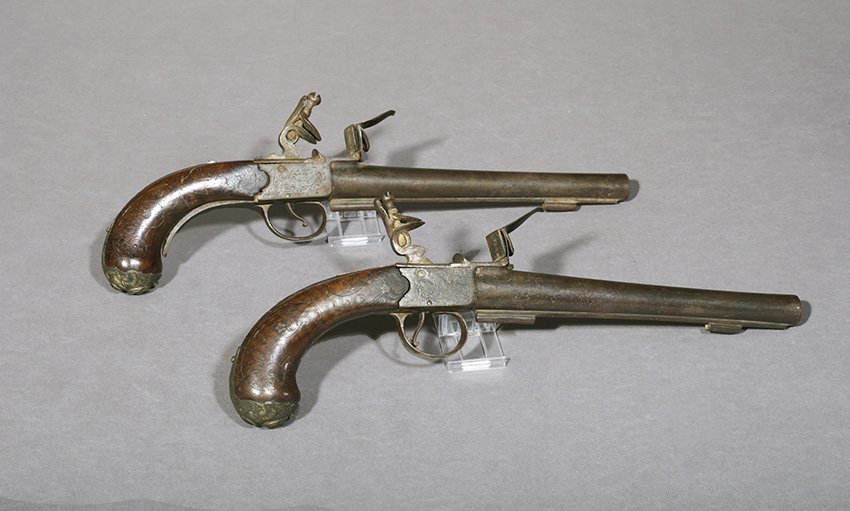Pair of Grice, London, Queen Anne Pistols: Pair of Grice, London, Queen Anne Pistols, second quarter 18th century, of traditional form, the wood grips retain the brass repousse butt caps and carved design previously inlaid with wire, the 9" ba