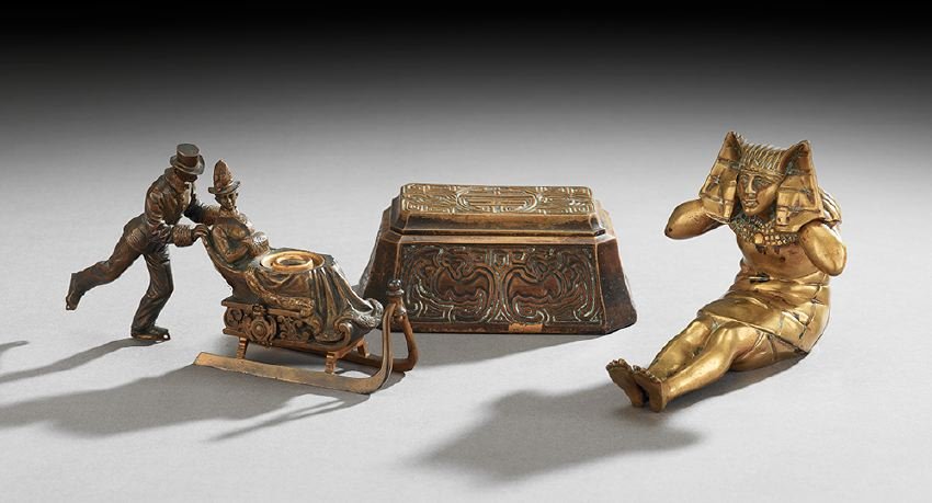 Collection of Three Bronze Inkwells: Collection of Three Bronze Inkwells, late 19th/early 20th century, including a Tiffany Aztec double inkwell, set with two molded glass inkpots, marked "Tiffany Studios, New York, 1763", h. 2-1/2", w. 