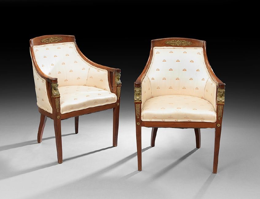 Pair of Empire-Style Mahogany Bergeres: Pair of Empire-Style Mahogany Bergeres, early 20th century, each with an ormolu-mounted crest above a padded back, joined by downswept arms on ormolu maiden's head uprights to the padded seat, raised 