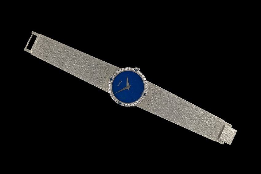 Piaget 18 Kt. White & Gold Lapis Dial Wristwatch: Piaget Eighteen-Karat White Gold, Diamond and Sapphire Wristwatch with Lapis Lazuli Dial, the textured brick link band attached to the round case with a diamond and sapphire bezel, the bezel set with