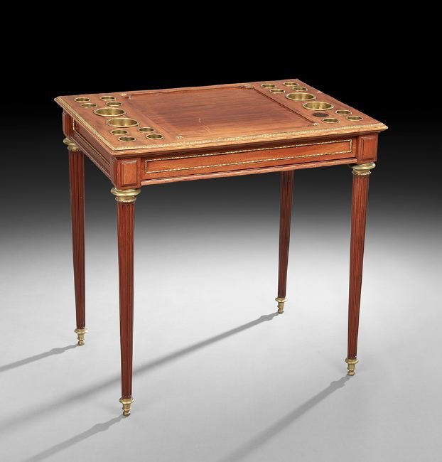 Louis XVI-Style Mahogany Games Table: Louis XVI-Style Mahogany Games Table, mid-19th century, the rectangular top with a central recessed panel flanked to either side by an arrangement of ten inset chip cups, above a paneled frieze over a