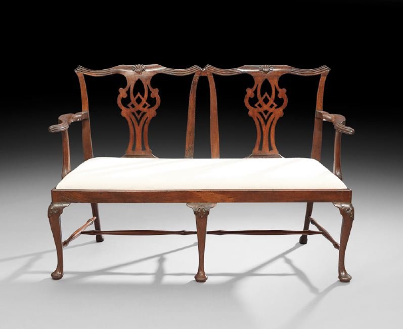 George III-Style Mahogany Settee: George III-Style Mahogany Settee, late 19th century, the shaped and earred crest over two pierced shell-carved splats, joined by shaped arms to the padded seat, raised on cabriole legs headed by folia