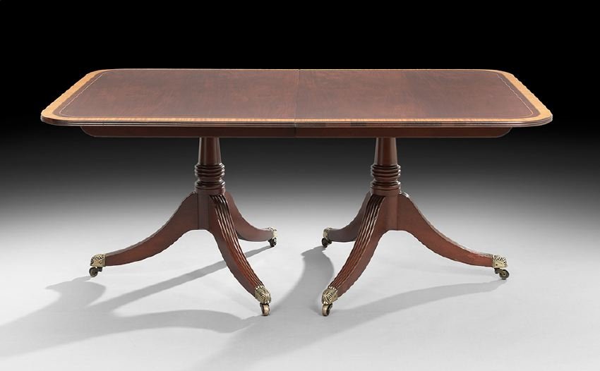 Regency-Style Mahogany Dining Table: Regency-Style Mahogany Double-Pedestal Dining Table, early 20th century, the top with a rosewood and satinwood banded edge and opening to accommodate three 18" leaves, the downswept reeded legs ending