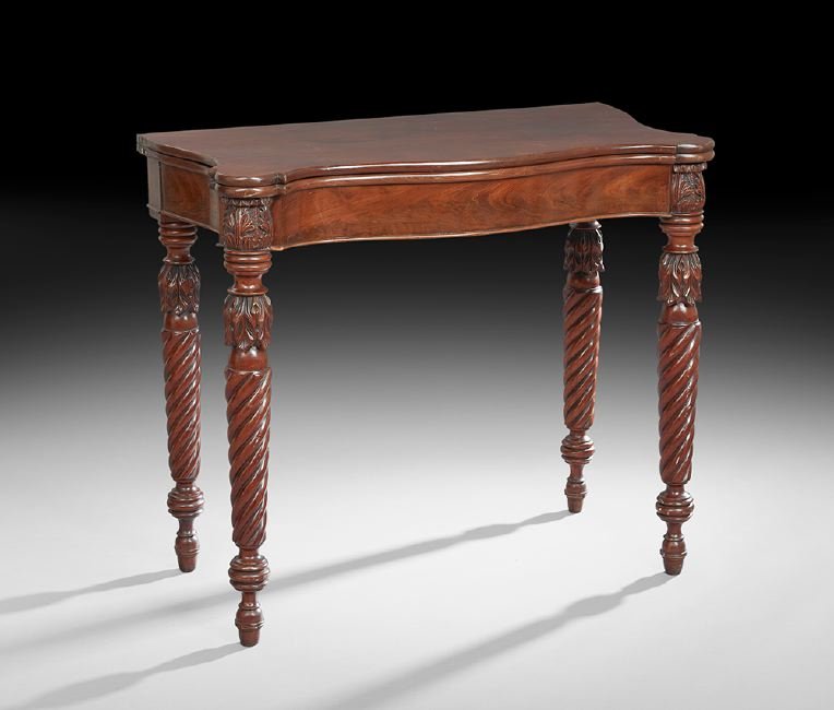 American Sheraton Mahogany Games Table: American Sheraton Mahogany Games Table, ca. 1825, in the manner of Samuel McIntire (1757-1811), Salem, Massachusetts, the serpentine fold-over top with ormolu corners, the conforming frieze flanked by