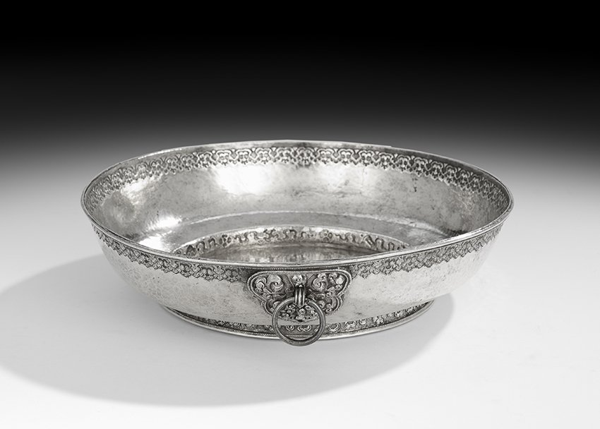 Southeast Asian Silver Bowl: Southeast Asian Silver Bowl second quarter 20th century, probably Balinese, of circular form with repousse scrolling band at the rim and foot, with applied boss-mounted ring handle, h. 2-3/4", dia. 11