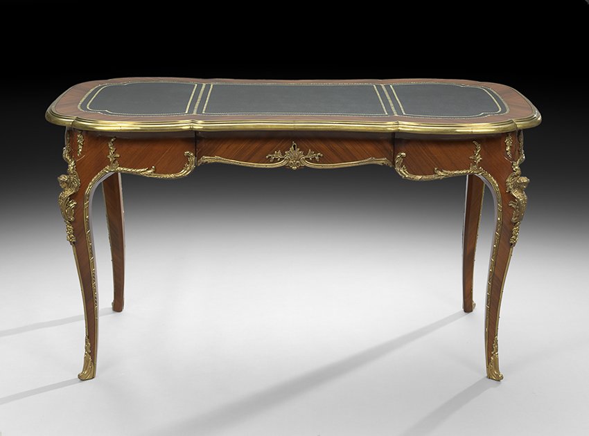 Louis XV-Style Mahogany Writing Table: Louis XV-Style Mahogany Writing Table 20th century, the shaped ovoid top with an inset gilt-tooled leather surface and ormolu banding, above a shaped frieze fitted with a single central drawer, raised
