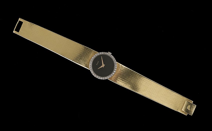 Lady's 18 Kt. Gold and Diamond Piaget Wristwatch: Lady's Eighteen-Karat Yellow Gold and Diamond Piaget Wristwatch the round black dial surrounded by a white gold bezel set with thirty-six round brilliant-cut diamonds, with an approximate total weight