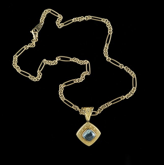 18 Kt. Gold & Blue Topaz Michelle Krespi Pendant: Eighteen-Karat Yellow Gold and Blue Topaz Michelle Krespi Pendant with Chain the pendant designed in the style of "Elizabeth Locke" and set with a cushion-shaped blue topaz cabochon, with an approxima