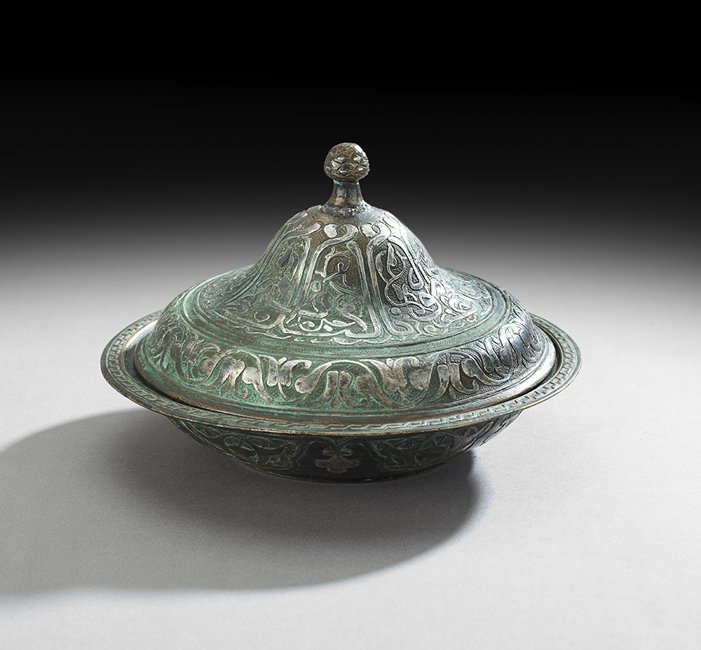 Middle Eastern Mixed Metal Covered Dish: Middle Eastern Mixed Metal Covered Dish, the circular dish with a domed cover, decorated with Islamic scrollwork, panels and flowers, h. 5", dia. 7-1/4".