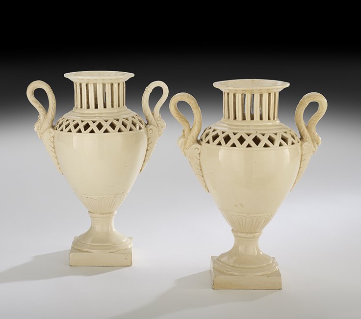Pair of Italian Neoclassical-Style Creamware Urns: Pair of Italian Neoclassical-Style Pierced Creamware Urns, second quarter 20th century, pierced with latticework and decorated with swan-molded handles, stamped "Italy", h. 14", w. 9", d. 5".