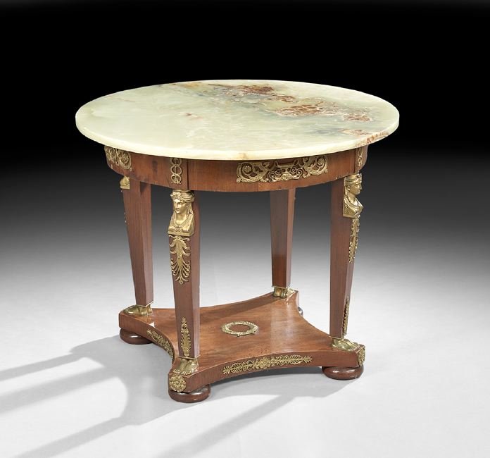Empire-Style Mahogany and Onyx-Top Gueridon: Empire-Style Mahogany and Onyx-Top Gueridon, early 20th century, the circular onyx top above a conforming ormolu-mounted frieze, joined by square supports with maiden's head capitals, to a concave str