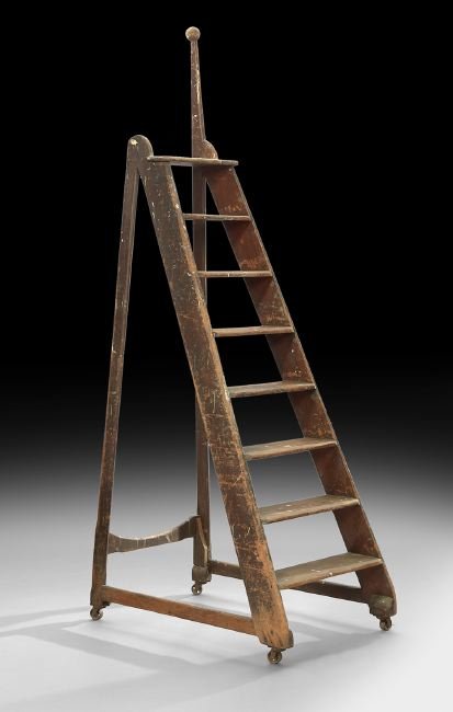Primitive Pine Eight-Tread Rolling Library Ladder: Primitive Pine Eight-Tread Rolling Library Ladder, late 19th century, of tapered form with each tread mortised into the side rails, fitted with large iron wheels, h. 97-1/2", w . 28", d. 42". Provenan