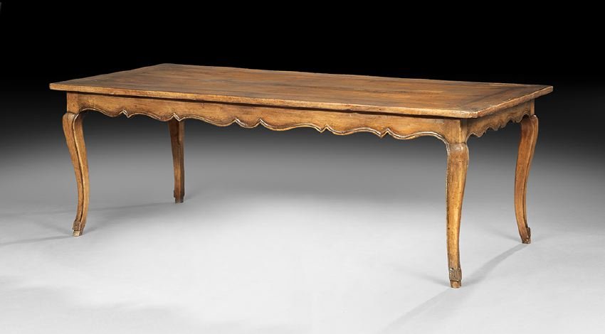 French Provincial Fruitwood Farmhouse Table: French Provincial Fruitwood Farmhouse Table, 19th century, the large rectangular top banded and with incised stringing, above a molded and scalloped frieze, raised on cabriole legs ending in hoof feet