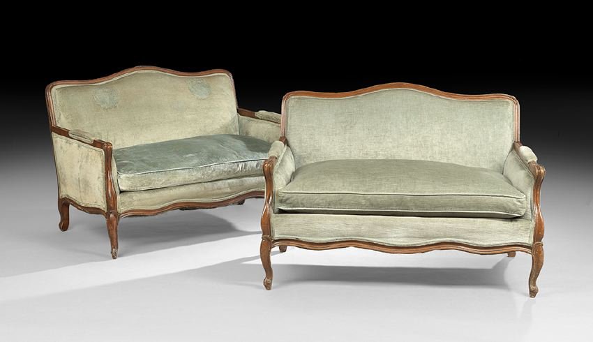 Pair of Provincial Louis XV-Style Settees: Pair of Provincial Louis XV-Style Fruitwood Settees, 20th century, each with a shaped and domed back within a molded frame, joined to the cushioned seat by padded closed arms, raised on cabriole legs 