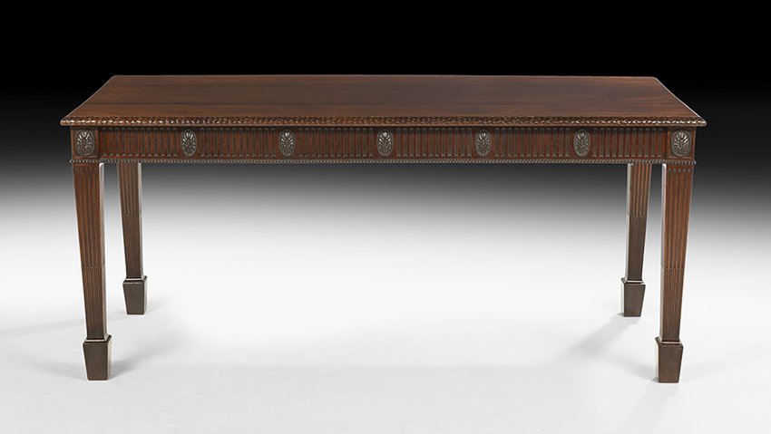 Pair of George III-Style Mahogany Serving Tables: Pair of George III-Style Mahogany Serving Tables, 20th century, in the Adam taste, each with a rectangular top with a laurel leaf-carved edge, above a conforming fluted frieze with carved floral pater