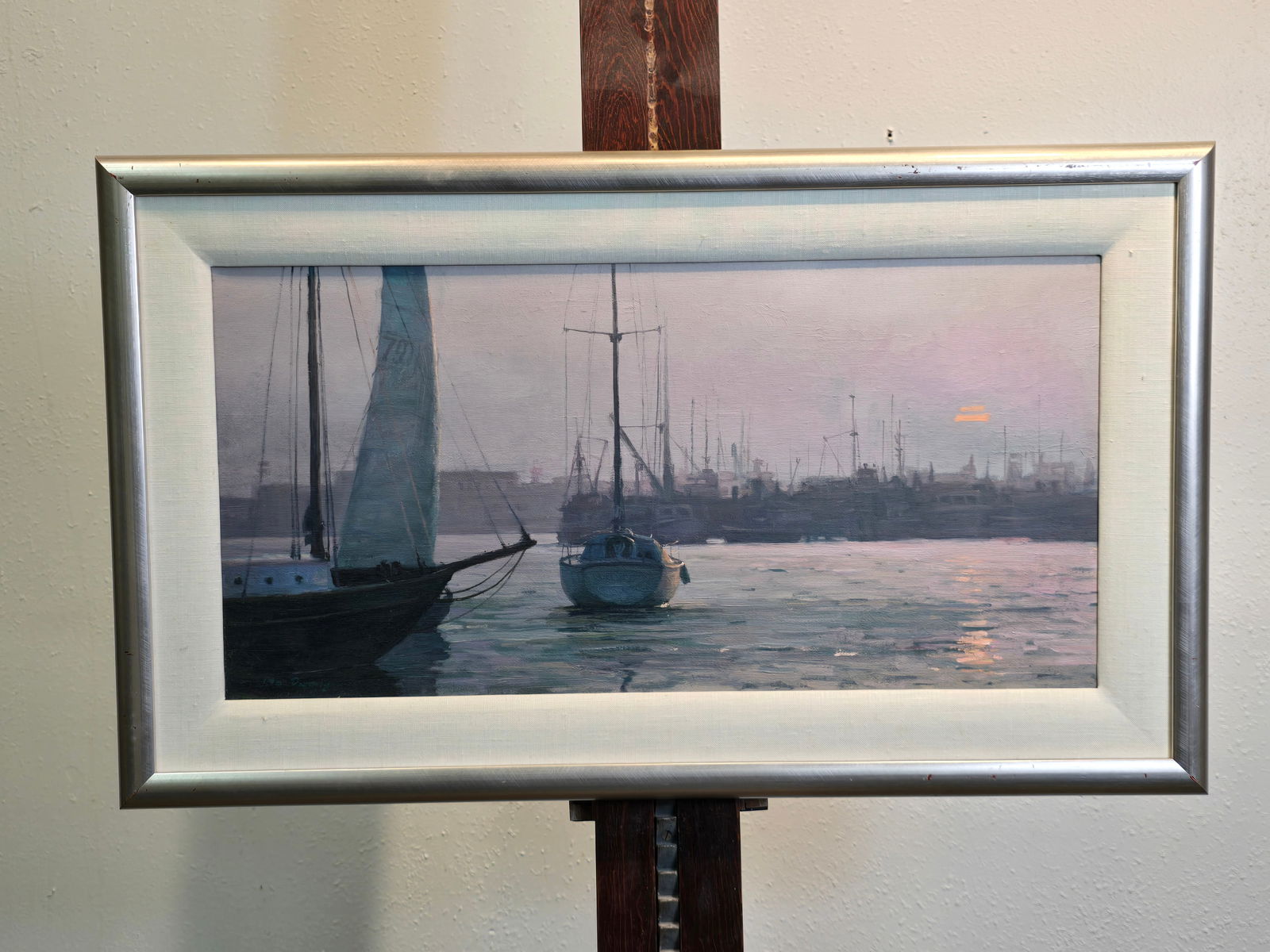 Mo Dafeng Newport Sunset Oil on Canvas Framed: Mo Dafeng Newport Sunset Oil on Canvas FramedCirca: Unknown17.5" H x 29.5" WMultiple sail boats in the harbor at sunset, violet light with orange sun in sky and reflected in water. Two prominent boats