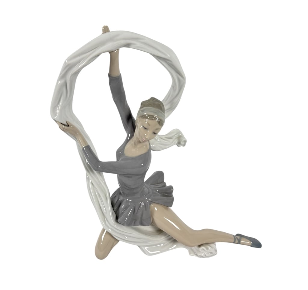 LLADRO DANCER WITH VEIL PORCELAIN FIGURINE: A porcelain figurine titled Dancer with Veil, manufactured by NAO, a subsidiary of the Lladro group. The piece depicts a rhythmic gymnast or dancer in a seated, dynamic pose. The figure is shown with 