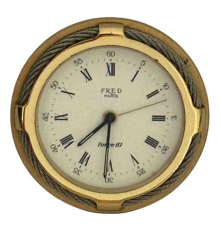 FRED PARIS FORCE 10 GILT METAL AND STEEL CABLE DEK: A Fred Paris desk clock from the Force 10 collection featuring a circular gold-toned metal case and an integrated folding easel stand. The bezel is accented with a signature maritime-inspired twisted 
