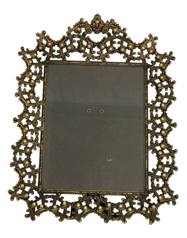 ROCOCO REVIVAL BRASS EASEL BACK PICTURE FRAME: This ornate rectangular picture frame is constructed from cast metal with a brass or bronze-toned finish. The frame features a wide, pierced border executed in the Rococo Revival style, consisting of 