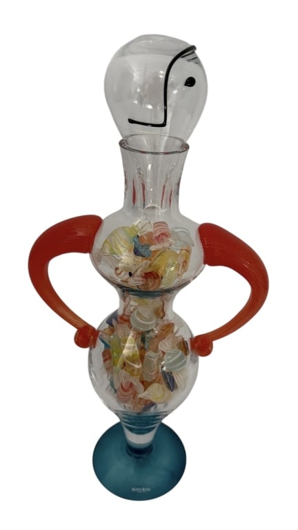 KOSTA BODA GLASS DECANTER SIGNED KJELL ENGMAN: Kosta Boda studio art glass decanter in the form of a figure, by Kjell Engman. The decanter has a modern design filled with colorful glass candy pieces. Signed on the bottom with number 89201. MEASURE