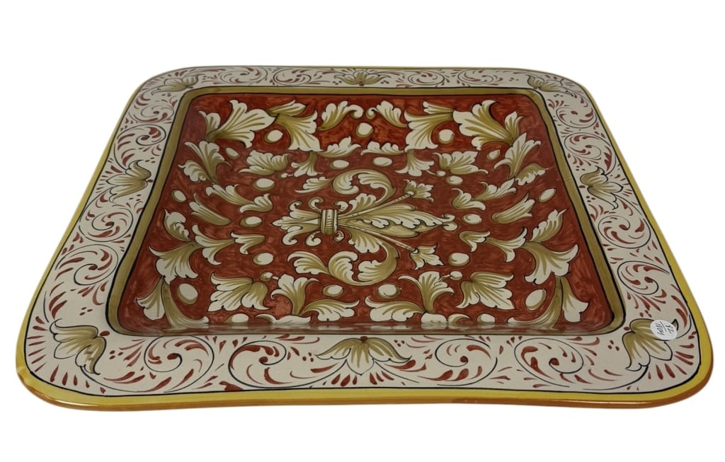 ITALIAN HAND PAINTED PORCELAIN SQUARE PLATE: This hand-painted porcelain plate is decorated in a Renaissance-revival style. The square form features rounded corners and a wide, upturned rim. The central square panel is finished with a terracotta