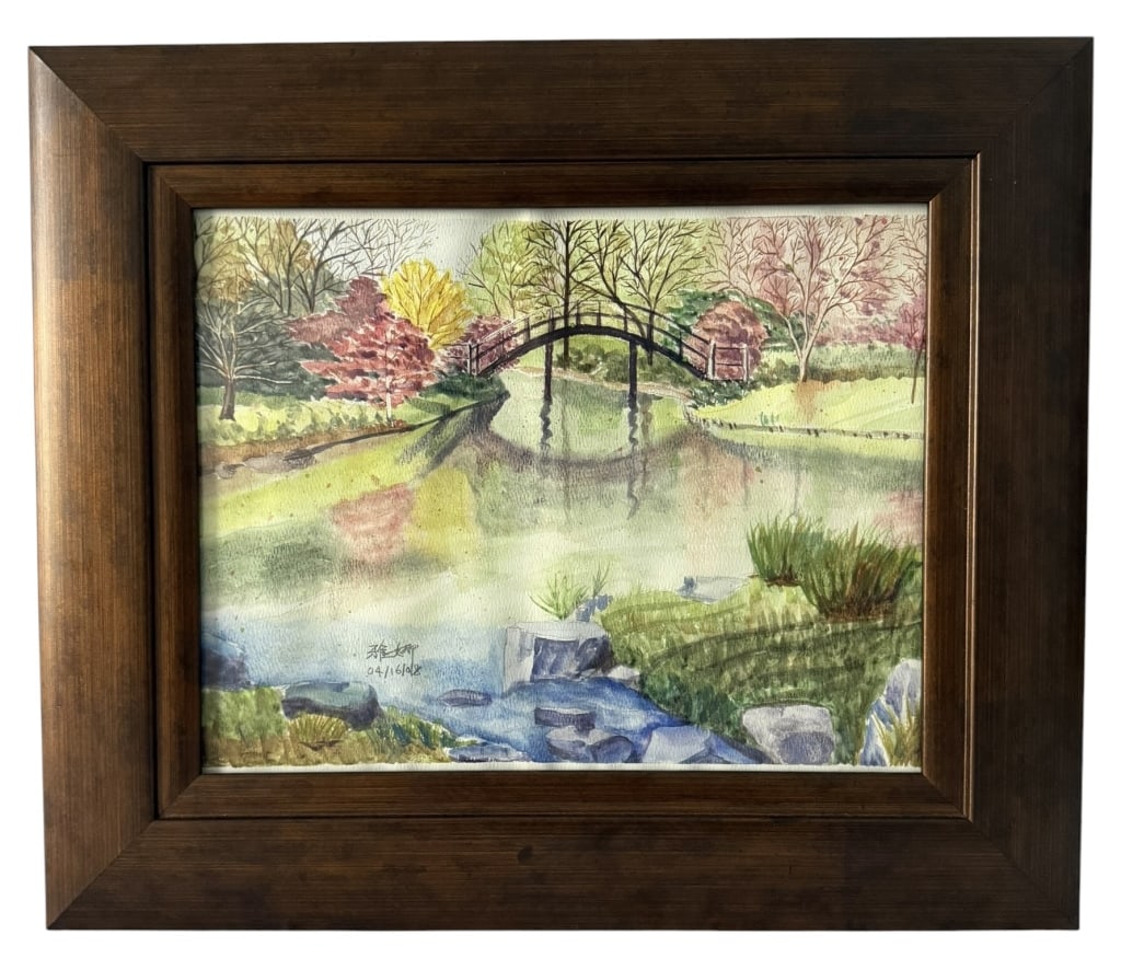 SIGNED ASIAN SCHOOL WATERCOLOR GARDEN LANDSCAPE: Original watercolor on paper depicting a serene Japanese-style garden landscape with an arched footbridge spanning a reflective pond, surrounded by trees, rocks and colorful foliage. Signed with Asian