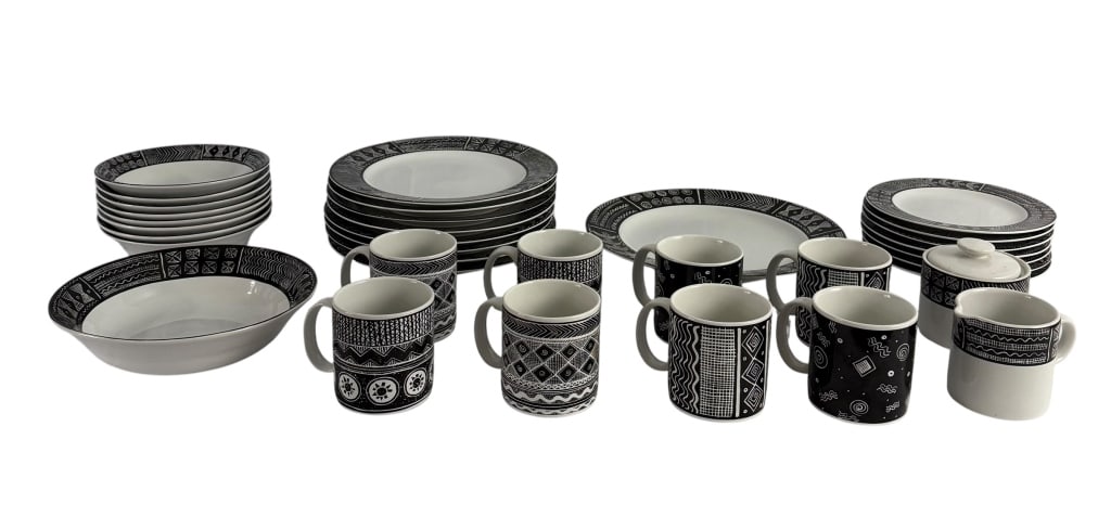 34-PIECE SAKURA BATIK BLACK & WHITE STONEWARE SET: Vintage 34-piece Sakura “Batik” stoneware dinner service, ©1993, featuring striking black-and-white geometric, abstract, and textile-inspired motifs. The individual pieces display a variety o