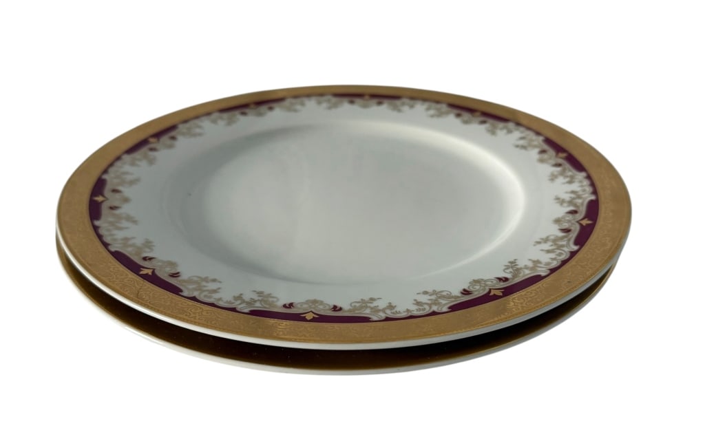 2 ROYAL PRAGUE PORCELAIN BURGUNDY & GILT PLATES: A pair of Royal Prague by Thun fine Bohemian porcelain plates, Karlovarský Porcelán, Czech Republic. Each plate features a white porcelain ground surrounded by an elaborate burgundy and gilt border,
