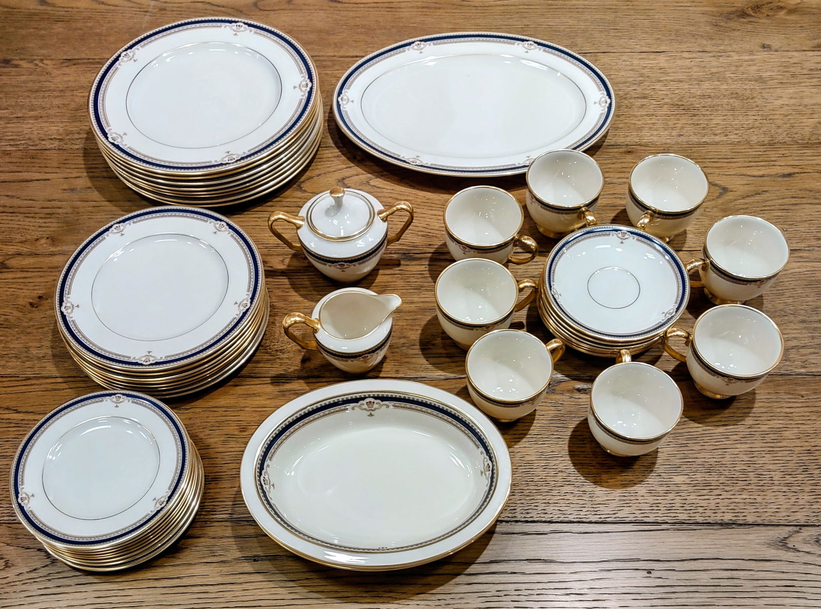 45 Piece china by "LENOX" Buchanan Design: 45 piece Buchanan china by Lenox Style discontinued, produced 1985 – 1999Off white field with cobalt, tan, and gold trim Urn-like, scrolled patterns with red and purple beaded accents 8 five piece p
