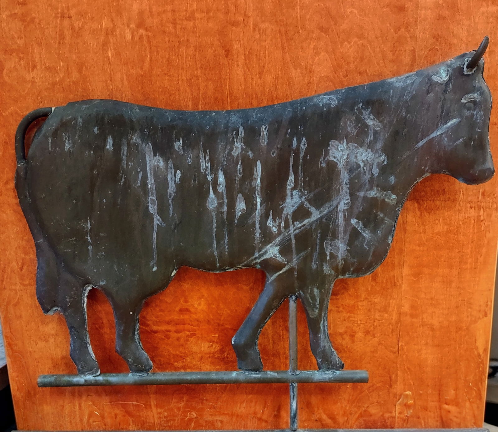 Weathered Cow Weathervane: Antique sheet metal cow-form weathervane figure in a stylized walking silhouette, mounted on its metal rod. The surface shows age-appropriate weathering and patina from outdoor use. A charming