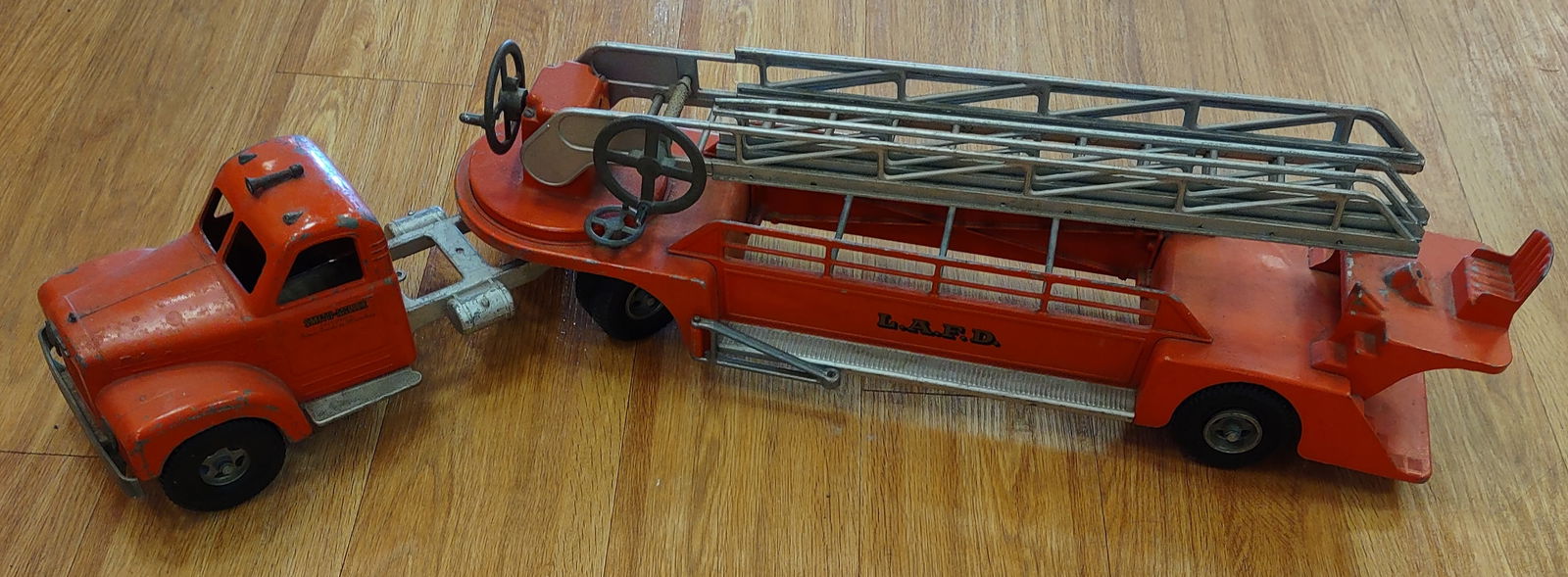Original Smith Miller B Mack Ladder Fire Truck: Original Smith Miller B Mack ladder fire truck. The cranks raises and moves the ladder. Original condition with paint loss and wear from play and age. Measures approximately 37" long.