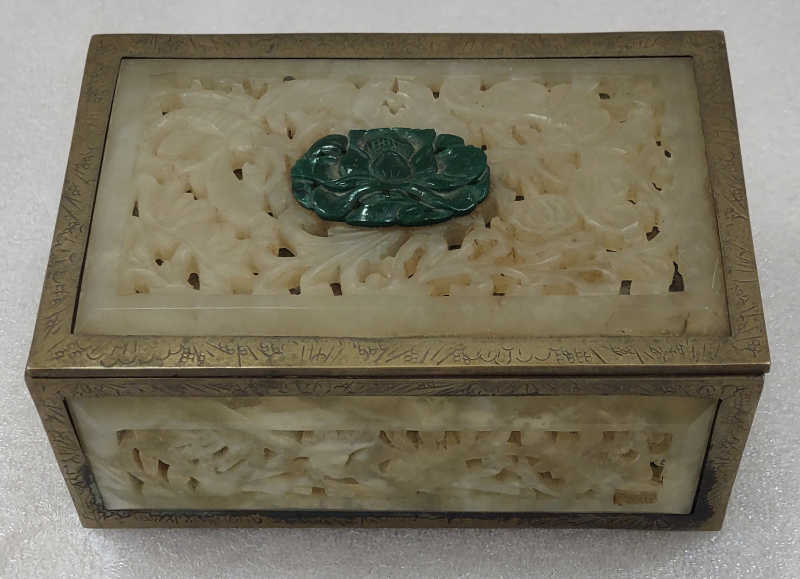 Antique Chinese Pierced Jade Box: Antique Chinese jade box featuring finely reticulated and pierced floral motif carving on the hinged lid and sides. Set within an embossed gilt metal frame of elegant decorative form. An intricate