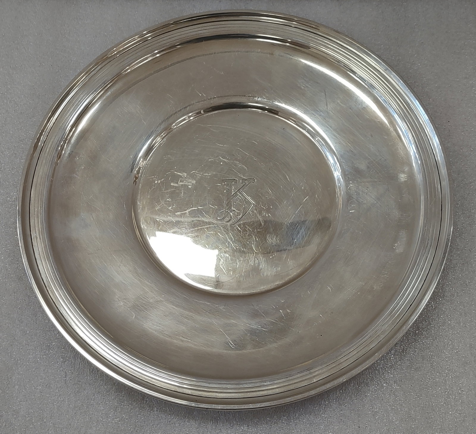 Sterling Silver 10.25" Serving Plate: Sterling Silver serving plate measuring approximately 10.25 inches round with monogrammed center. Stamped “Sterling” on the underside and weighing approximately 11.95 troy ounces. Shipping: