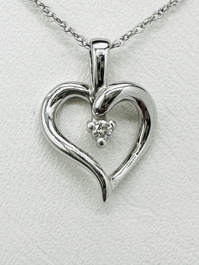 14KT White Gold Natural Diamond Heart Pendant and Chain # 2103: # 2103 14KT White Gold Natural Diamond Heart Pendant and Chain 1 piece diamond 0.03 carat 18” chain with spring ring clasp closure Pendant and Chain Weight: 1.30 grams Pendant: 14 mm x 10 mm