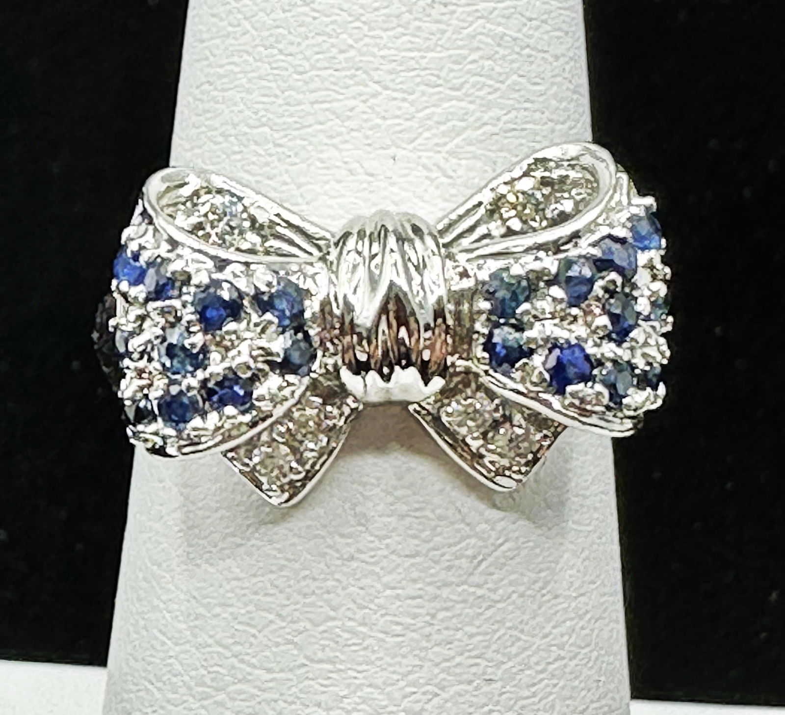 Natural Diamond And Sapphire Bow Ring In 14K White Gold Size 6.5 - J11136: * Natural Diamond and Sapphire Bow Ring. * Main Material: 14KT White Gold * 6 pcs diamond 0.10Carat ( t.w.) * Clarity VS-SI, Color G-K * 20 pcs Sapphire 0.60 Carat (t.w.) * Ring Weight 5.20 grams * Ri