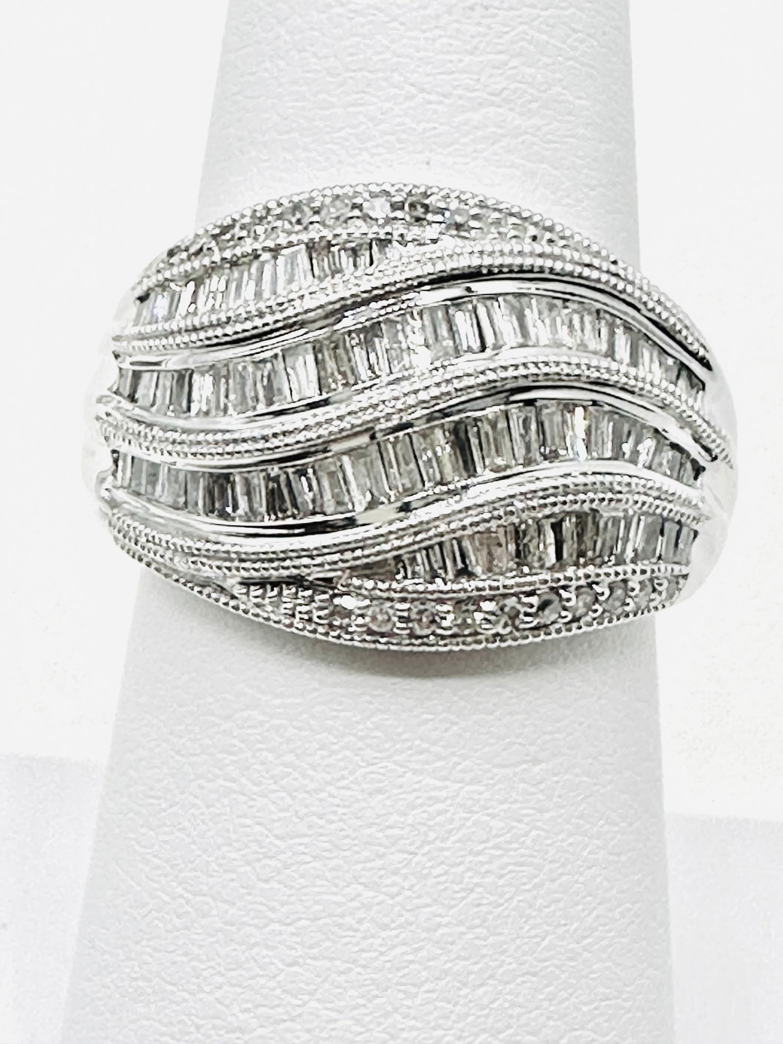 14KT White Gold Diamond Swirl Fancy Ring Size 7 - J11330: * 14KT White Gold Diamond Swirl Fancy Ring * Round and Baguette Cut Diamond 0.80 carat (t.w.) * Ring Weight: 7.20 grams * Ring size 7 * Diamond Clarity VS-I, Color G-K, * Condition: New in Box * J1133