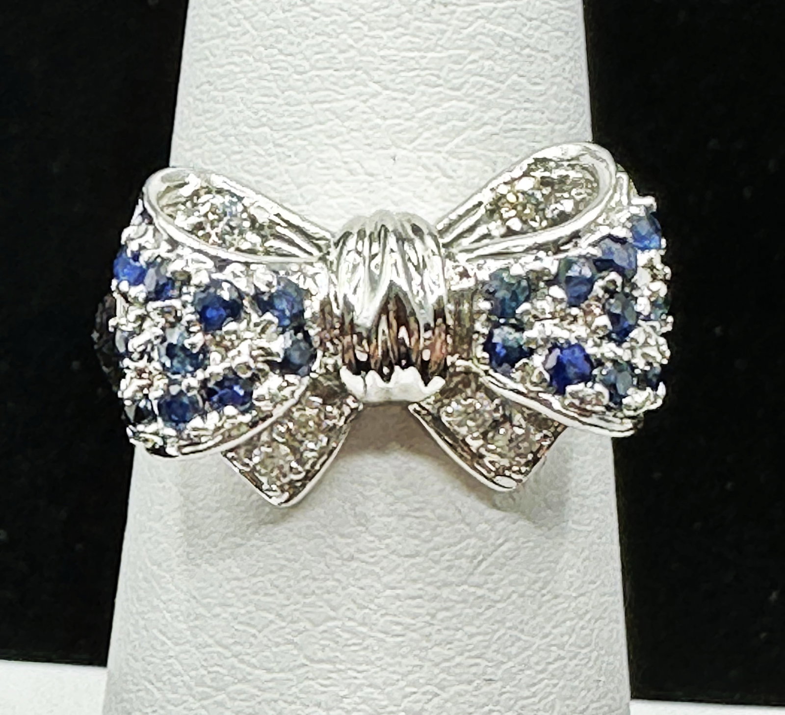 Natural Diamond And Sapphire Bow Ring In 14K White Gold Size 6.5 - J11136: * Natural Diamond and Sapphire Bow Ring. * Main Material: 14KT White Gold * 6 pcs diamond 0.10Carat ( t.w.) * Clarity VS-SI, Color G-K * 20 pcs Sapphire 0.60 Carat (t.w.) * Ring Weight 5.20 grams * Ri