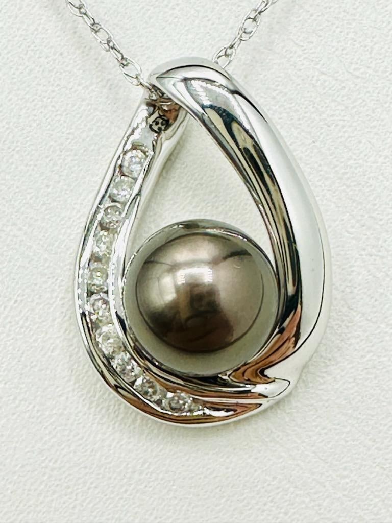 14KT White Gold Natural Diamond Cultured Tahitian Pearl Pendant and Chain # 2101: # 2101 14KT White Gold Natural Diamond Cultured Tahitian Pearl Pendant and Chain 10 pieces diamond 0.18 carat(t.w.) 1 piece pearl: 8 mm 18” chain with spring ring clasp closure Pendant and Chain