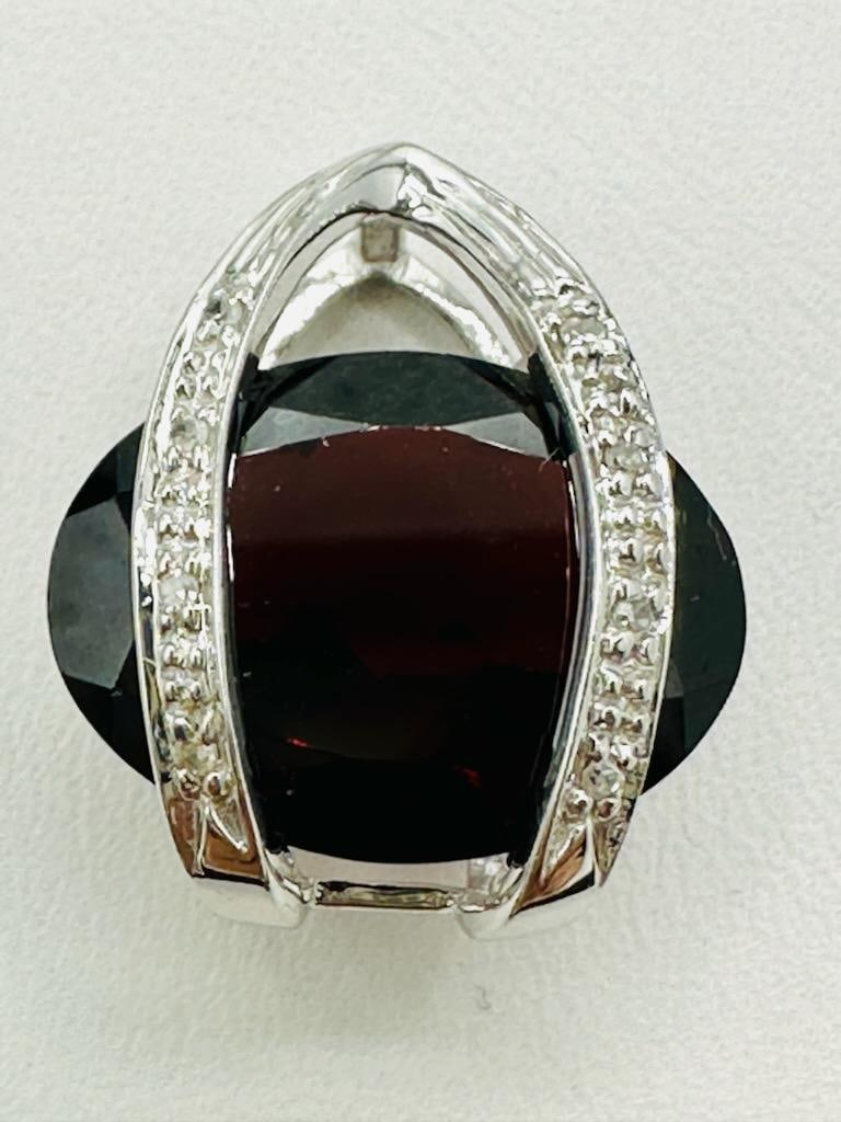 14KT White Gold Natural Diamond and Garnet Slide Pendant # 2173: # 2173 14KT White Gold Natural Diamond and Garnet Slide Pendant 8 pieces diamond 0.05 carat 1 piece oval garnet Pendant Weight: 3.80 grams Pendant size: 19 mm x 16 mm