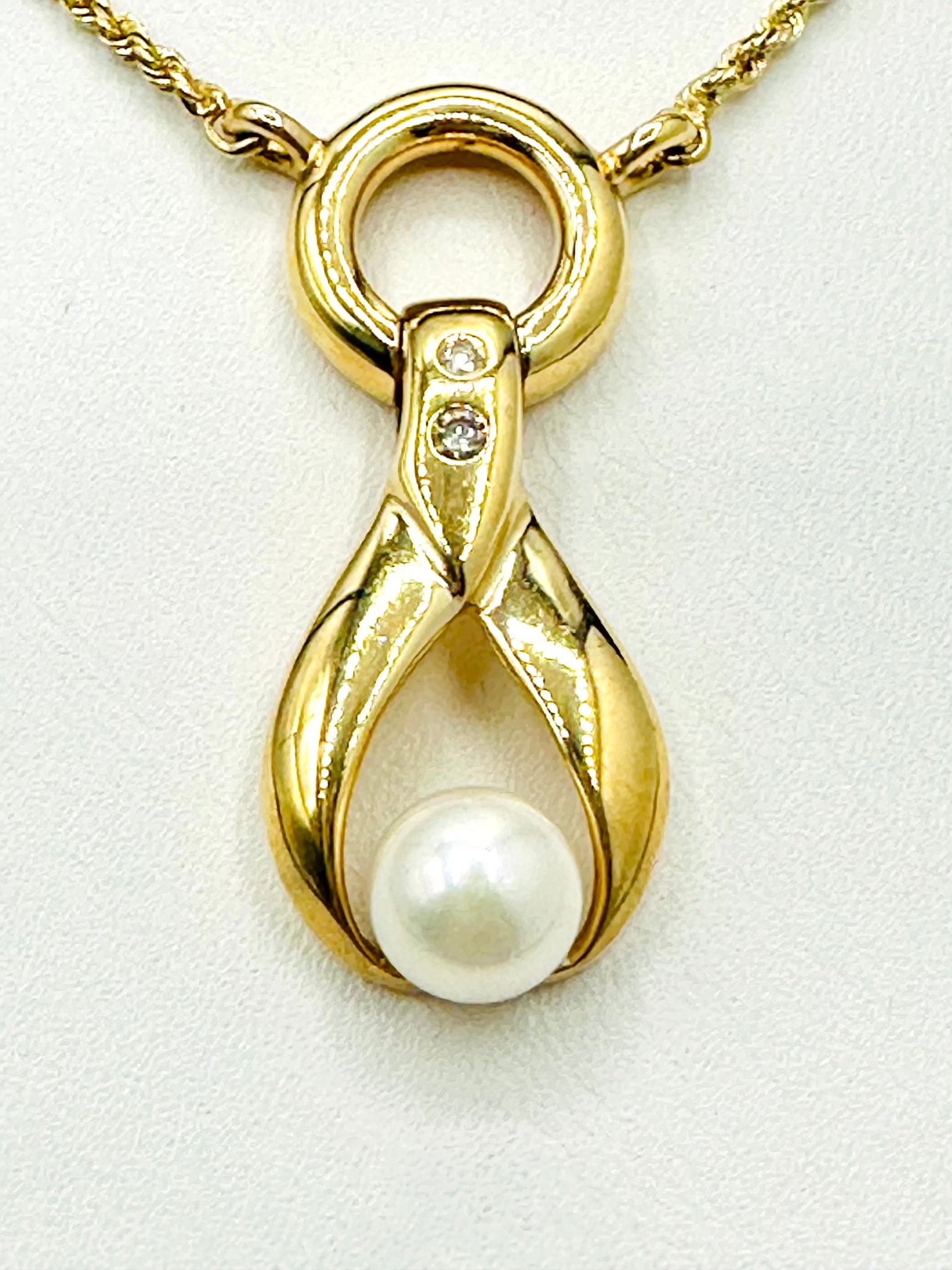 Natural Diamond and Pearl 14KT Yellow Gold Necklace # 2270: # 2270 Natural Diamond and Pearl 14KT Yellow Gold Necklace 2 pieces diamond 0.06 carat( t. w.) 1 piece culture pearl 7 mm 18” rope chain Pendant and Chain Weight: 9.20 grams Pendant size: 34 mm 