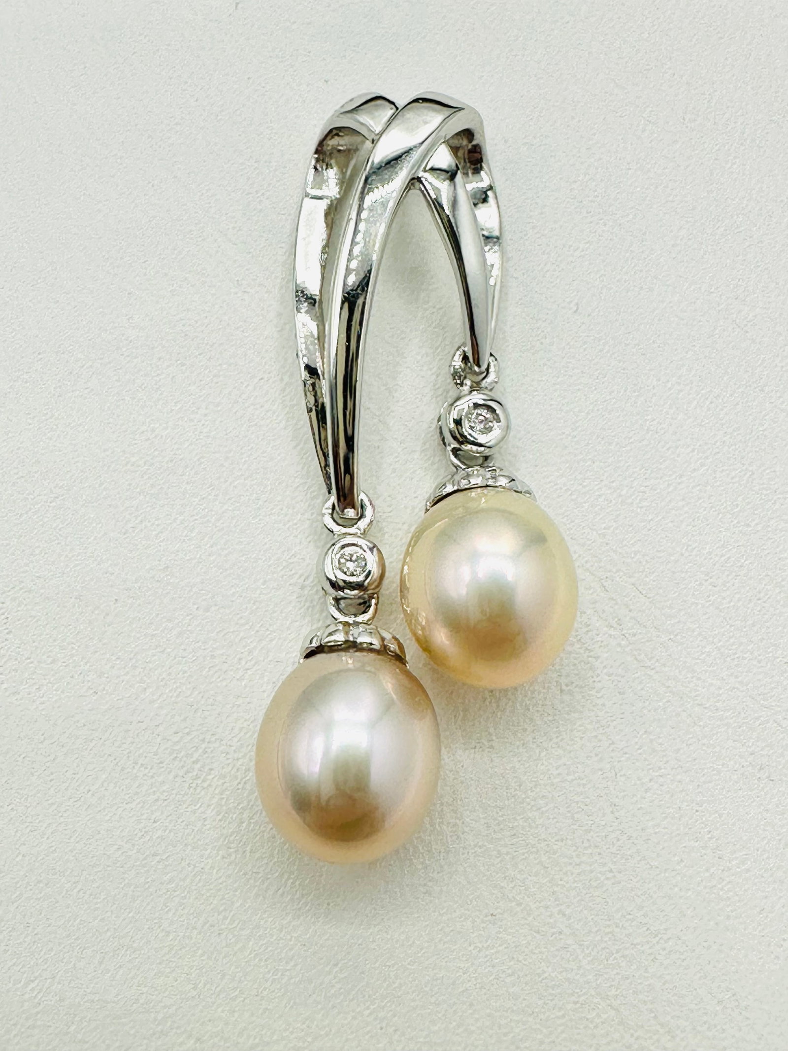 18KT White Gold Double Pearl Pendant # 2393: # 2393 18KT White Gold Double Pearl Pendant 2 pieces the cultured freshwater pearl: 7.5 mm Pendant Weight: 3.50 grams Pendant Size: 34 mm X 9.5 mm