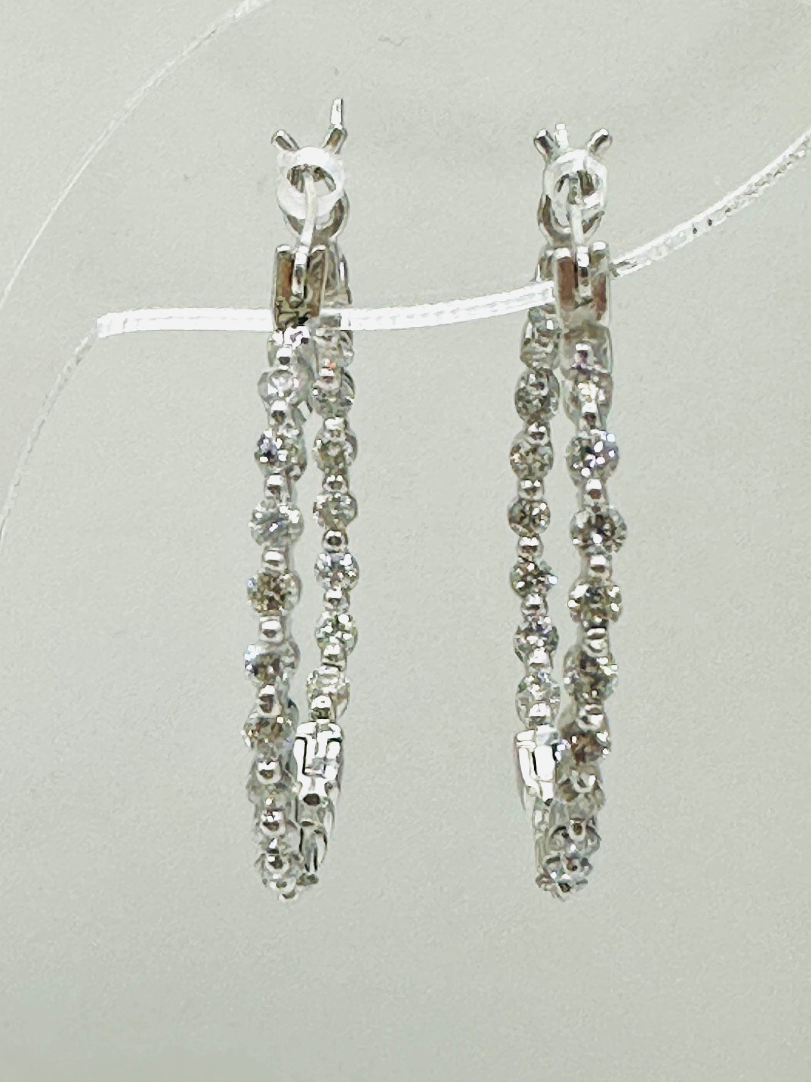 Pair of Natural Diamond in and out Hoop Earrings, 14KT White Gold # 2573: # 2573 Pair of Natural Diamond in and out Hoop Earrings, 14KT White Gold 40 pieces diamond 1.00 carat(t.w.) Earrings Weight: 3.50 grams(t.w.) Click top closure Earrings Size: 25 mm X 2 mm