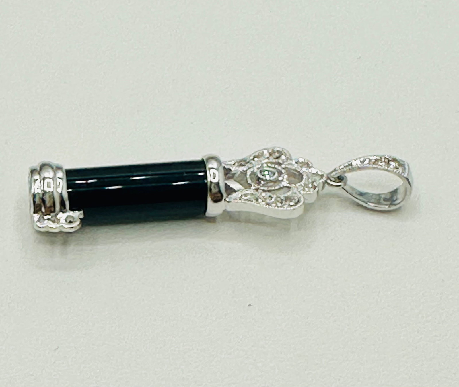 14KT White Gold, Natural Diamond and Onyx Key Pendant # 2711: # 2711 14KT White Gold, Natural Diamond and Onyx Key Pendant 12 pieces diamond 0.11 carat(t.w.) 1 piece onyx Pendant Weight: 2.30 grams (t.w.) Pendant size: 36 mm X 9.50 mm