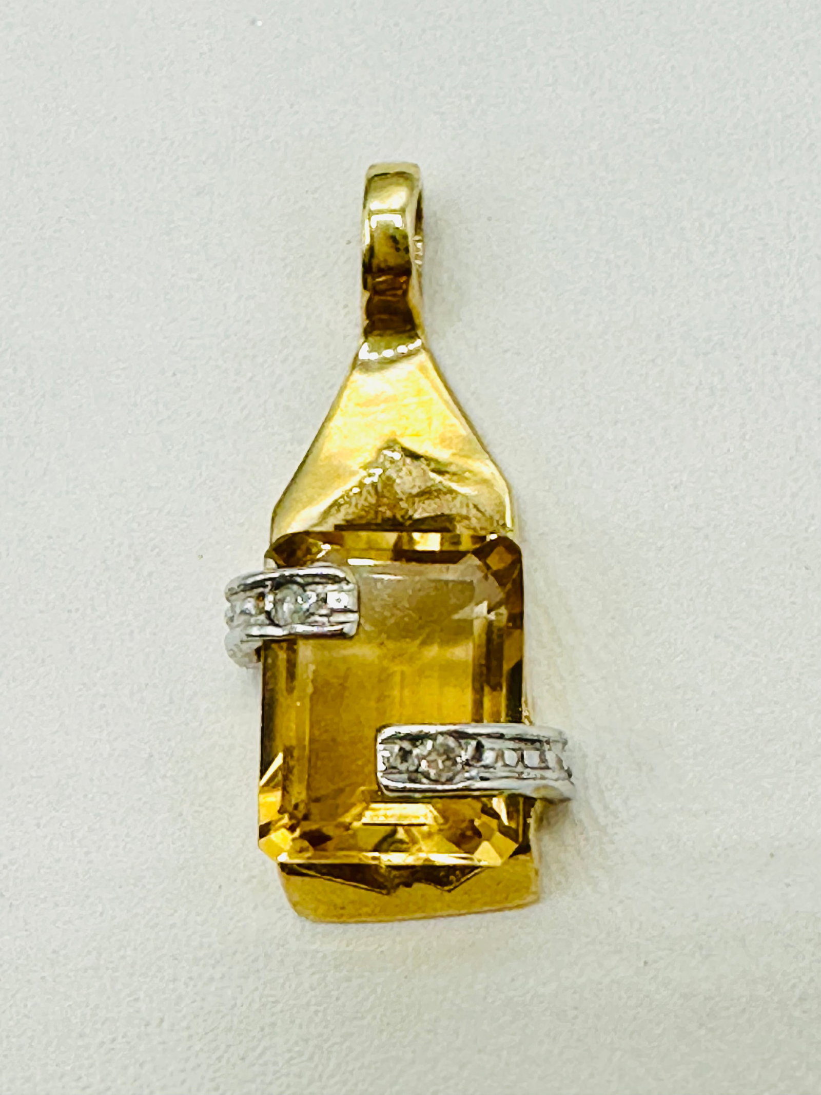 14KT Yellow Gold Yellow Topaz and Diamond Pendant # 2778: # 2778 14KT Yellow Gold Yellow Topaz and Diamond Pendant 1 piece emerald cut yellow topaz 2 pieces diamond Pendant Weight: 2.0 grams (t.w.) Pendant size: 21 mm X 9.5 mm