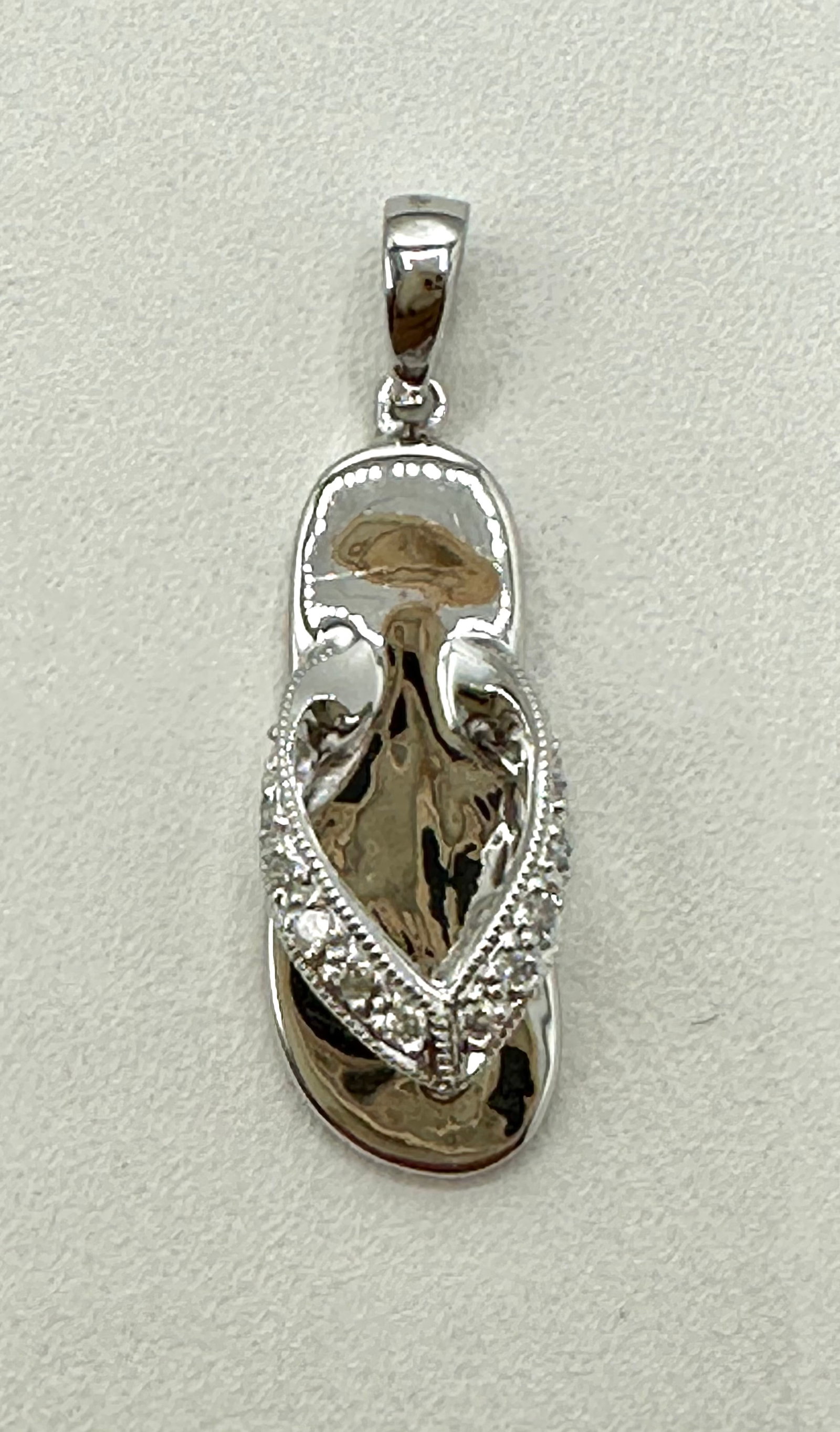 Natural Diamond Slipper Pendant, 18KT White Gold # 2793: # 2793 Natural Diamond Slipper Pendant, 18KT White Gold 12 pieces diamond 0.07 carat( t.w.) Pendant Weight: 1.8 grams(t.w.) Pendant Size: 24 mm x 7 mm