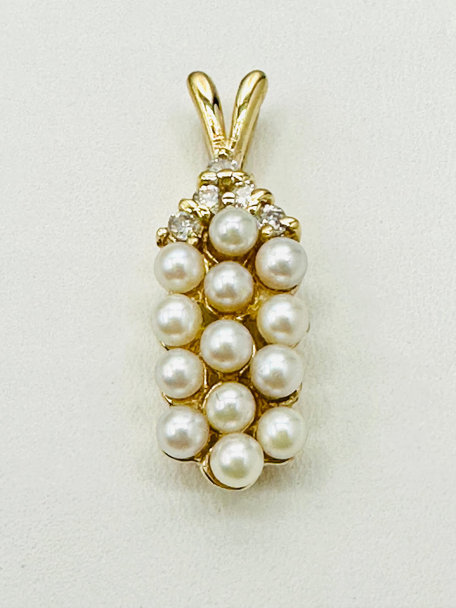 14KT Yellow Gold, Natural Diamond and Pearl Pendant # 2551: # 2551 14KT Yellow Gold, Natural Diamond and Pearl Pendant 5 pieces diamond 0.18 carat(t.w.) 13 pieces freshwater Pearl Pendant Weight: 2.40 grams (t.w.) Pendant size: 24 mm X 8 mm