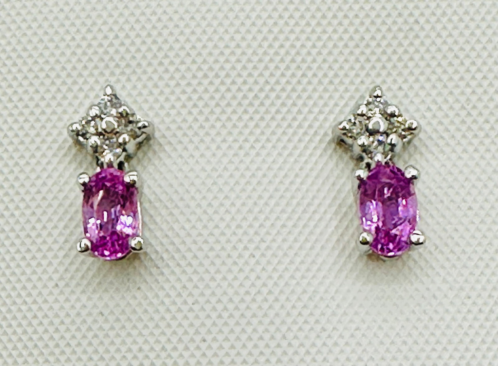 14KT White Gold,Pair of Natural Diamond and Oval Pink Sapphire Earrings # 2742: # 2742 14KT White Gold,Pair of Natural Diamond and Oval Pink Sapphire Earrings 8 pieces diamond 0.15 carats(t.w.) 2 pieces pink sapphire 0.50 carat(t.w.) Post Black Earrings Weight: 1.30 grams(t.w.) E