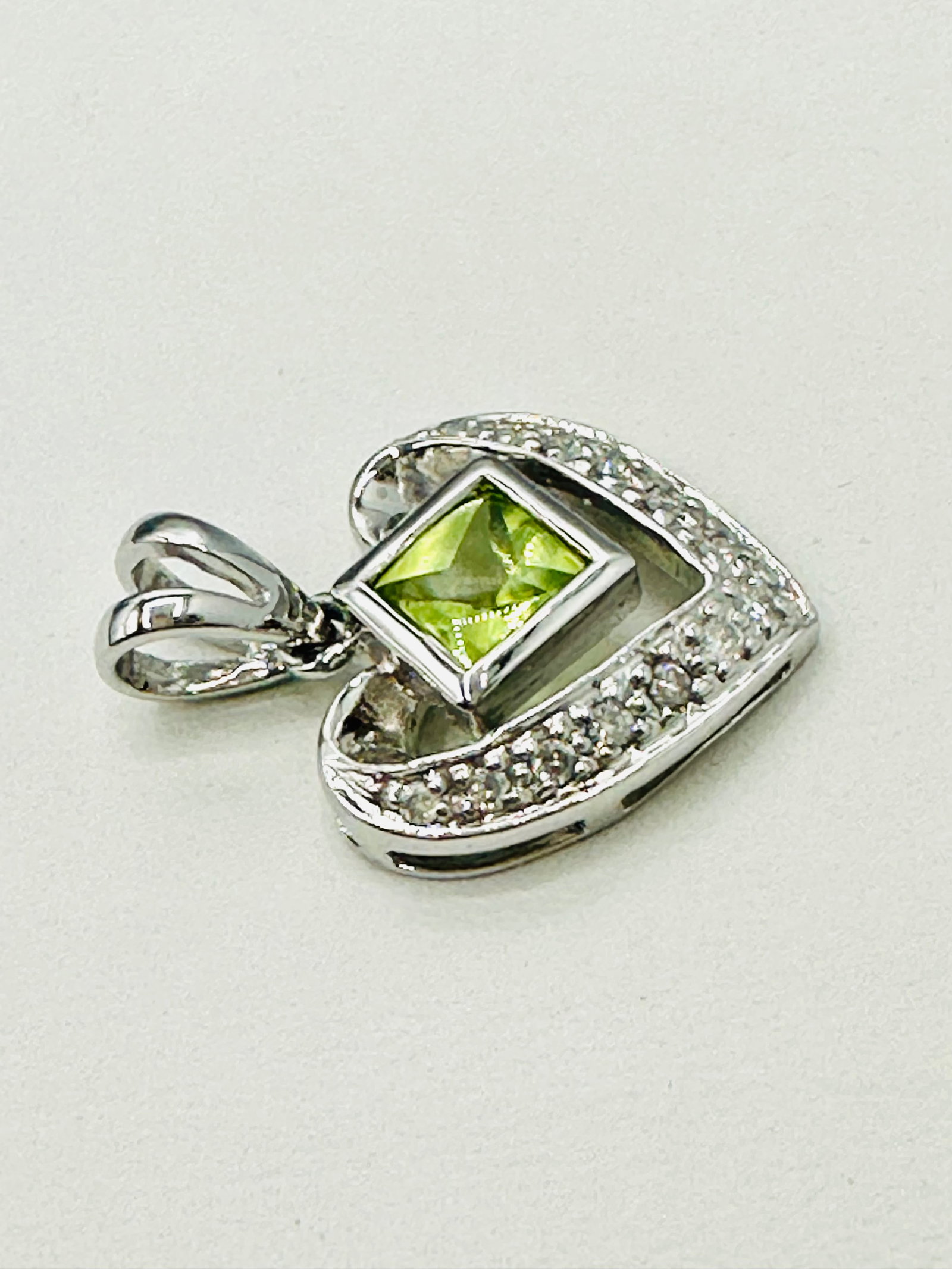 14KT White Gold, Natural Diamond and Peridot Heart Pendant # 2749: # 2749 14KT White Gold, Natural Diamond and Peridot Heart Pendant 13 pieces diamond 0.05 carat(t.w.) 1 piece peridot Pendant Weight: 1.50 grams (t.w.) Pendant size: 18 mm X 12 mm