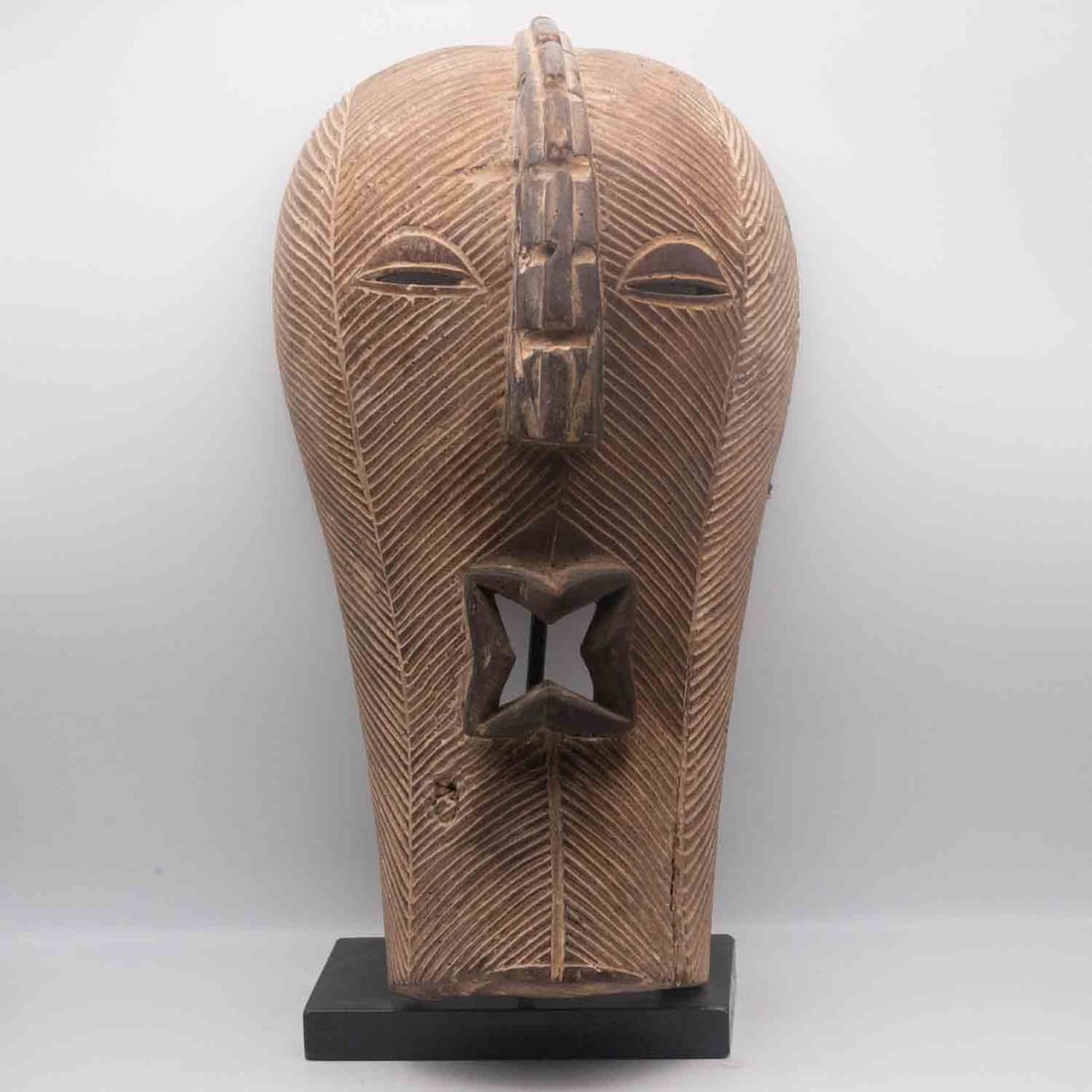 Vintage 20th C. African Songye Carved Wood Kifwebe Mask on Stand: Medium: Carved Wood Size: 7.5x6.5x14.3 inches Age/Detail: Vintage 20th C. African Songye Condition: cracks, check photo for condition reference. Losses to the crest and lower edge. Stand has minor wea